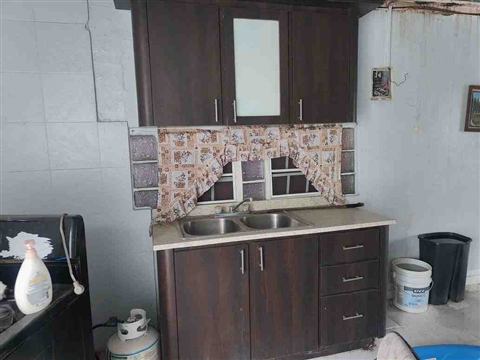 Cocina del segundo nivel con gabinetes de madera oscura y fregadero doble